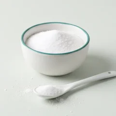 کاسهٔ نمک سفید و یک قاشق چای‌خوری نمک